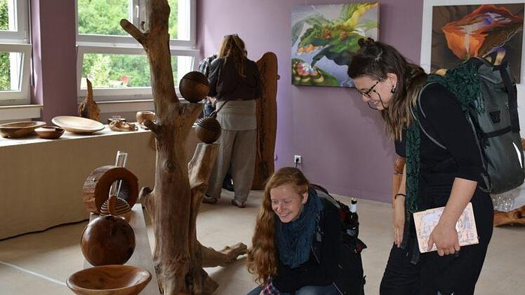 Waleria Sadkow und Johanna Owsian von der Holzbildhauerschule in Empfertshausen interessieren sich für die Objekte des Holzkünstler Jess Cobb. Foto: Andreas Lomb
