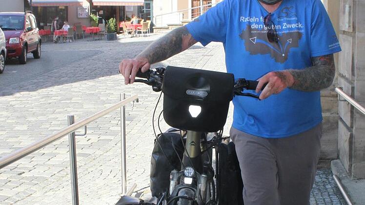Radfahrer Oliver Trelenberg kennt kein unpassendes Wetter. Er radelt bei Sonnenschein, br&uuml;tender Hitze und auch bei Regen. Die vielen Tattoos erinnern ihn an schwierige Zeiten. Foto: Sonny Adam