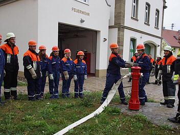 Das Anschließen eines Wasserschlauches an den Hydranten muss geübt werden, kritisch beobachtet von Leo Pfennig und Werner Denner (ganz rechts). Foto: Anton Then