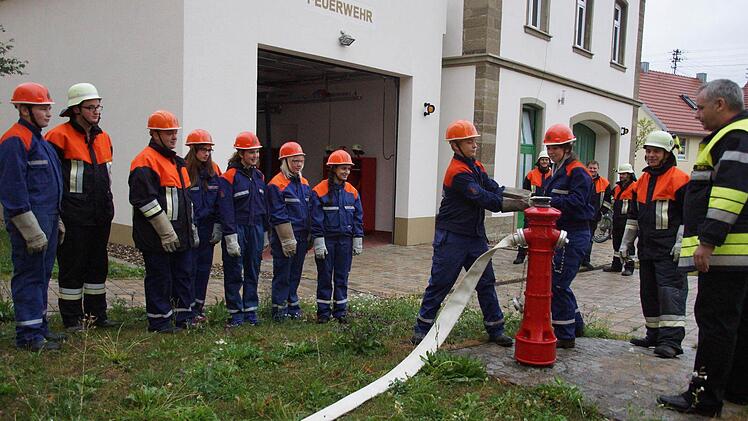 Das Anschließen eines Wasserschlauches an den Hydranten muss geübt werden, kritisch beobachtet von Leo Pfennig und Werner Denner (ganz rechts). Foto: Anton Then