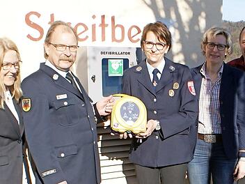 Am Feuerwehrgerätehaus wird der Defibrillator angebracht. Foto: hl