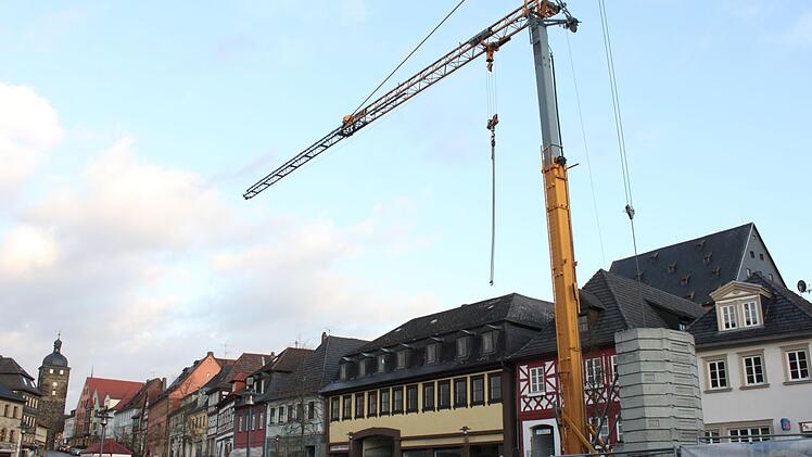 Blick auf die größte Investition der Stadt Lichtenfels in den nächsten Jahren: das Gebäude Marktplatz 10. Dort soll nicht nur eine neue und größere Bücherei, sondern auch ein Zugang zum Stadtschloss geschaffen werden, dessen Dachgiebel oben rechts zu sehen ist. Die Baustelle vorne im Bild (mit Kran) betrifft allerdings das an Hausnummer 2 entstehende Zentrum für 3D-Druck ("Archiv der Zukunft") der Hofmann-Gruppe. Foto: R. Popp