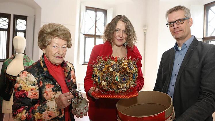 Jahrzehntelang hat Irmgard Edle von Traitteur (links) mit dem von Dagmar Rosenbauer (mitte) gefertigten Hohen Kranz für das Thema Tracht geworben. Jetzt werde mit der Brautkrone das Pfalzmuseum bereichert, freut sich OB Uwe Kirschstein. Fotos: Barbara Herbst