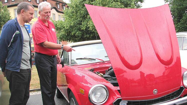 Oldtimerliebhaber fahren bei jedem Wetter! Für den Hofheimer Hellmuth Wegner (2. von links) war es deshalb keine Frage, trotz des Regens in den Gleisenauer Schlosspark zu kommen und seinen "Spider" zu zeigen.