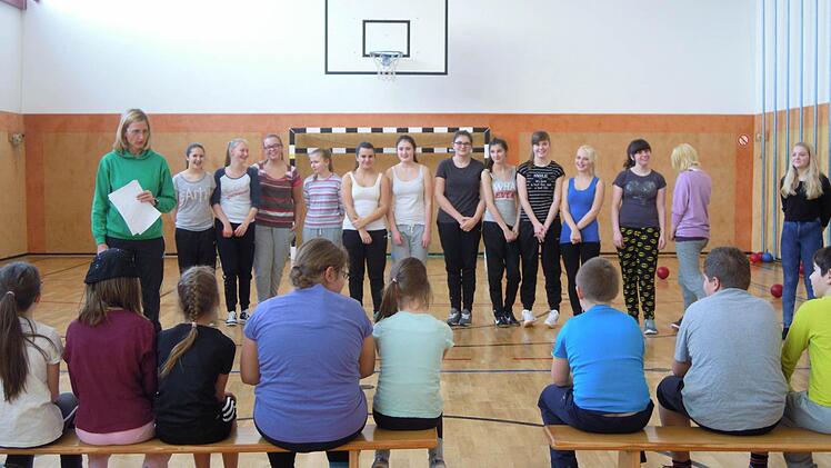 Elke Hausmann (links) stellt ihre noch etwas verhaltenen Sportschülerinnen (im Hintergrund) den Grundschülern vor. Foto: Julia Raab