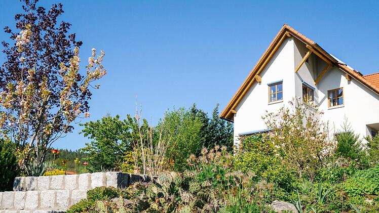 Auf dem höchsten Punkt ihres Grundstücks haben Susanne Knauer-Marx und Claus Marx ihr Haus gebaut. Damit ist es von allen Seiten mit Bäumen, Blumen oder Sträuchern umgeben. Foto: Marian Hamacher