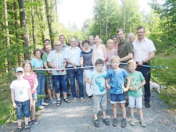 Zur Inbetriebnahme des Forstwirtschaftsweges zwischen Rotschreuth und Seelach schnitten alle Beteiligten symbolisch ein Band durch. Mit im Bild der Maßnahmenträger, Dritter Bürgermeister Markus Wich (Dritter von rechts), und Bau- und Revierleiter Christoph Maar (Fünfter von links). Foto: K.- H. Hofmann