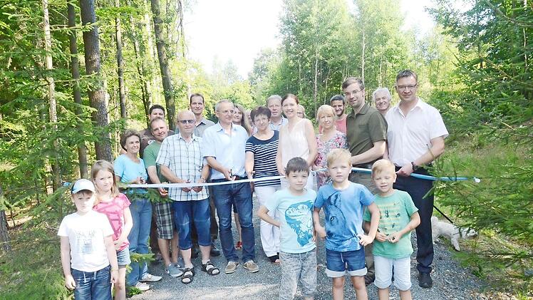 Zur Inbetriebnahme des Forstwirtschaftsweges zwischen Rotschreuth und Seelach schnitten alle Beteiligten symbolisch ein Band durch. Mit im Bild der Maßnahmenträger, Dritter Bürgermeister Markus Wich (Dritter von rechts), und Bau- und Revierleiter Christoph Maar (Fünfter von links). Foto: K.- H. Hofmann