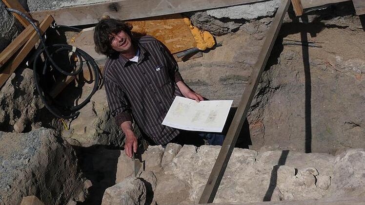 Archäologe Reiner Burkard ist begeistert von den Funden im Hof der ehemaligen Synagoge in Wiesenbronn.  Ganz genau dokumentiert er die Lage einzelner Steine, die Beschaffenheit der Ausgrabungsschichten und den verwendeten Mörtel. Fotos: Karina Brock