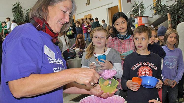 Viele hungrige Münder stopfen: Erika Hüfner teilt rund zehn Kilogramm Frucht-Joghurt an die Grundschüler aus. Fotos: Ulrike Müller