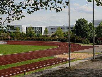 Blick über die Sprunggrube und die 400-Meter-Laufbahn, die in den bevorstehenden Sommerferien saniert werden sollen. Der Rasen wird vorerst nicht erneuert. Im Hintergrund sind die Gebäude des Schulzentrums Haßfurt zu sehen. Foto: Günther Geiling