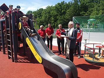 Einer neuen Verwendung führte der FC Eltingshausen einen ehemaligen Tennisplatz zu: Minifußballfeld und Spielgelände. Auf unserem Foto segnet Pfarrer Edwin Ziegler die Anlage, während die Kinder bereits die Rutsche belagern. Im Hintergrund von links Roland Metzler, Michael Seufert und Gerhard Fischer.  Foto: Stefan Gegiger