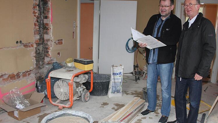 Dekan Hans Roppelt (rechts) und Kirchenpfleger Frank Ramming schauen sich auf der Großbaustelle um. Im Erdgeschoss war bisher nur gestampfter Lehmboden und mit Linoleum belegt. Foto: Sonja Adam