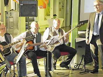 Der Leiter des Beruflichen Schulzentrums, Joachim Meier (rechts), selbst Hobby-Schlagzeuger, lauscht der "Lehrer-Houseband", die gestern zu seiner Verabschiedung in der Aula aufspielte. Auch zwei Schülerinnen der FOS 13 glänzten mit einem musikalischen Auftritt. Foto: Peter Müller