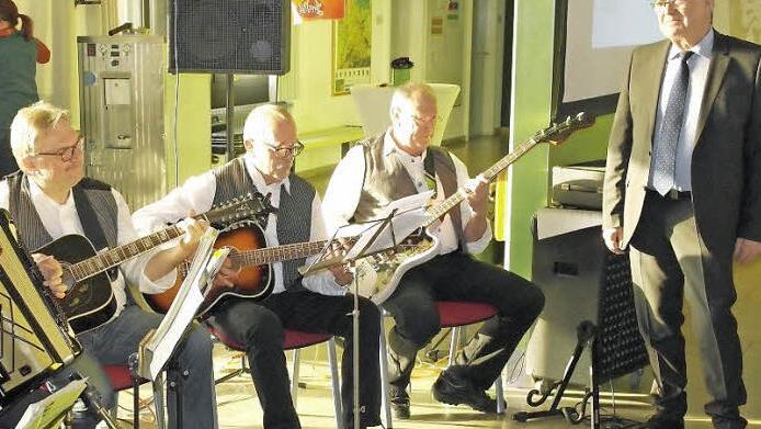 Der Leiter des Beruflichen Schulzentrums, Joachim Meier (rechts), selbst Hobby-Schlagzeuger, lauscht der "Lehrer-Houseband", die gestern zu seiner Verabschiedung in der Aula aufspielte. Auch zwei Schülerinnen der FOS 13 glänzten mit einem musikalischen Auftritt. Foto: Peter Müller