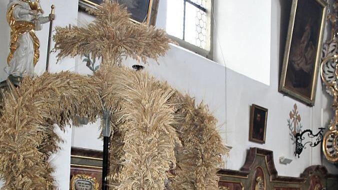 Rita Simon neben der Erntekrone in der Buttenheimer Pfarrkirche St. Bartholom&auml;us. Beim Schm&uuml;cken ist sie jedes Jahr immer gerne dabei.
