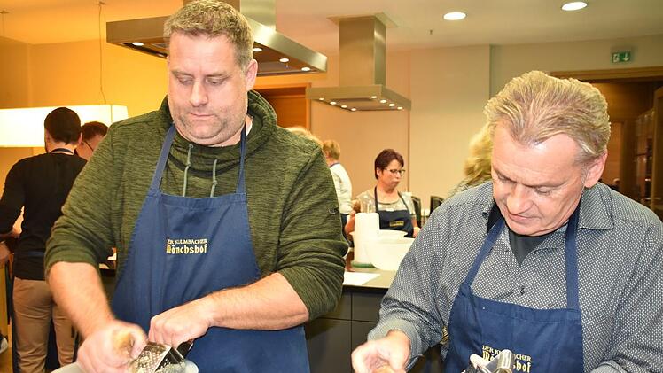 Matthias Heindl und Manfred Gareis reiben altbackenes Brot, das für das sogenannte Quellstück verwendet wird. Foto: Uschi Prawitz