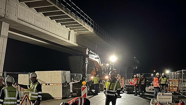 Bauarbeiter treffen Vorbereitungen f&uuml;r den Abriss einer Autobahnbr&uuml;cke in der Nacht