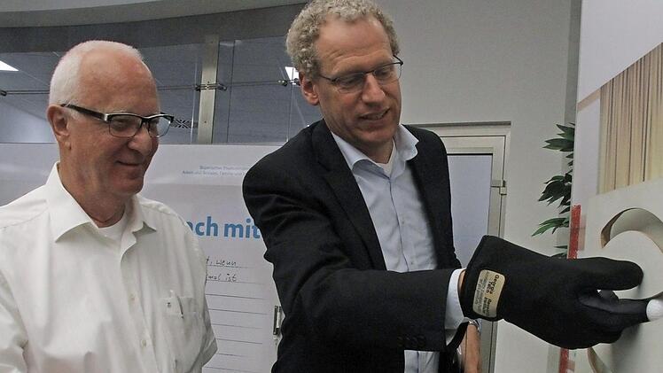 Wolfgang Jörg (links) und German Hacker ergründen die Schwierigkeiten beim Fingerspitzengefühl mit Spezialhandschuhen.