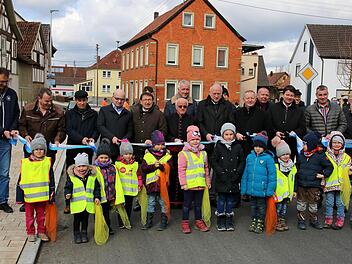 Freie Fahrt! Zur offiziellen Freigabe der Ortsdurchfahrt zerschnitten  Vertreter aus Politik, Verwaltung, der Baufirma, der Geistlichkeit ein  Band. Die Stücke bekamen die Kinder aus den Kindergärten in Brünn und  Thundorf (vorne) als Erinnerung. Foto: Dieter Britz