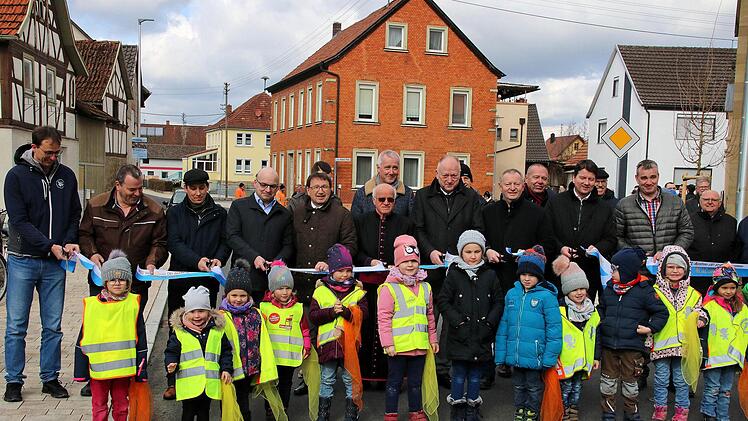 Freie Fahrt! Zur offiziellen Freigabe der Ortsdurchfahrt zerschnitten  Vertreter aus Politik, Verwaltung, der Baufirma, der Geistlichkeit ein  Band. Die Stücke bekamen die Kinder aus den Kindergärten in Brünn und  Thundorf (vorne) als Erinnerung. Foto: Dieter Britz