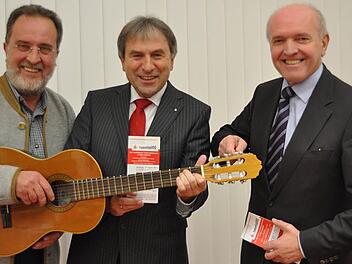 Die Gitarre steht beim diesjährigen musikalischen Förderwettbewerb "Talentissimo" im Mittelpunkt. Veranstalter sind die Musikschule des Landkreises Rhön-Grabfeld, vertreten durch Schulleiter Ulrich Wehner (links), unterstützt von der Stiftung der Sparkasse Bad Neustadt mit Sparkassendirektor Roland Schmautz. Schirmherr ist Landrat Thomas Habermann (rechts), der schon mal versucht die Gitarre zu stimmen. Foto: Friedrich