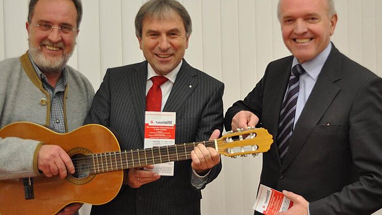 Die Gitarre steht beim diesjährigen musikalischen Förderwettbewerb "Talentissimo" im Mittelpunkt. Veranstalter sind die Musikschule des Landkreises Rhön-Grabfeld, vertreten durch Schulleiter Ulrich Wehner (links), unterstützt von der Stiftung der Sparkasse Bad Neustadt mit Sparkassendirektor Roland Schmautz. Schirmherr ist Landrat Thomas Habermann (rechts), der schon mal versucht die Gitarre zu stimmen. Foto: Friedrich