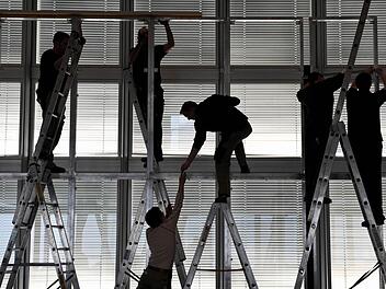 Arbeiter sind mit dem Abbau einer Bühne beschäftigt. Mit der Entwicklung der Wirtschaft, der Gesellschaft und der Arbeitskultur beschäftigt sich der KKV in seinem Jahresthema. Ergebnisse werden bei der Jubiläumsfeier des Kitzinger Ortsverbandes vorgestellt. Foto: dpa