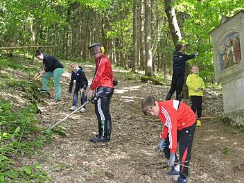 Die Ministranten von Glosberg machen den Prozessionsweg für die Fatima-Prozessionen frei. Sie beseitigen Hindernisse, wie Steine, Äste, Grasbewuchs und mehr, damit der steile Anstieg zur Waldkapelle für die Gläubigen etwas begehbarer wird.  Foto: Karl-heinz Hofmann