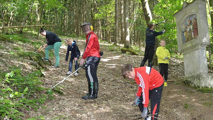 Die Ministranten von Glosberg machen den Prozessionsweg für die Fatima-Prozessionen frei. Sie beseitigen Hindernisse, wie Steine, Äste, Grasbewuchs und mehr, damit der steile Anstieg zur Waldkapelle für die Gläubigen etwas begehbarer wird.  Foto: Karl-heinz Hofmann