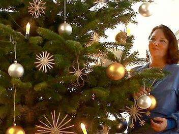 Der Weihnachtsbaum im Klinikum, an dem Margit Thieret steht, trägt elektrische Ketzen, denn offenes Feuer ist im Krankenhaus verboten. Fotos: Manuel Stark
