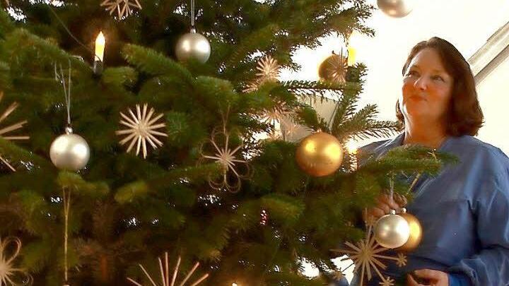 Der Weihnachtsbaum im Klinikum, an dem Margit Thieret steht, trägt elektrische Ketzen, denn offenes Feuer ist im Krankenhaus verboten. Fotos: Manuel Stark