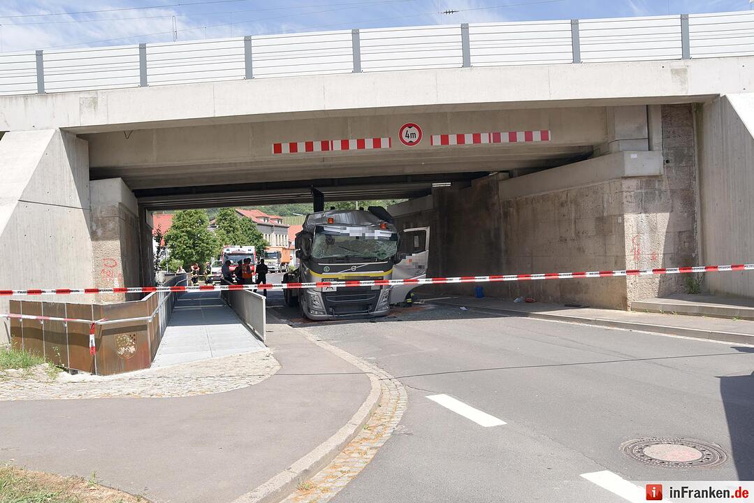 Lkw mit Kranaufbau fährt sich unter Brücke fest