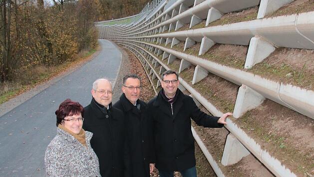 Die Euerdorfer B&uuml;rgermeisterin Patricia Schie&szlig;er (von links), Michael Fuchs, Leiter des Staatlichen Bauamtes Schweinfurt, der Auraer B&uuml;rgermeister Thomas Hack und R&uuml;diger K&ouml;hler vom Bauamt begutachten die Raumgitterwand unterhalb der Stra&szlig;e von Euerdorf nach Aura. Foto: Ralf Ruppert