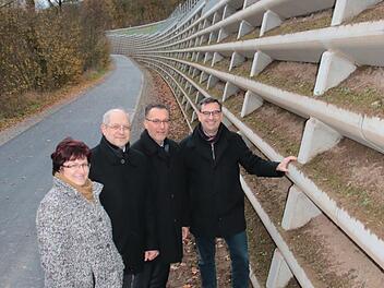 Die Euerdorfer Bürgermeisterin Patricia Schießer (von links), Michael Fuchs, Leiter des Staatlichen Bauamtes Schweinfurt, der Auraer Bürgermeister Thomas Hack und Rüdiger Köhler vom Bauamt begutachten die Raumgitterwand unterhalb der Straße von Euerdorf nach Aura. Foto: Ralf Ruppert