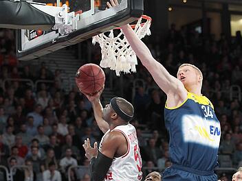 Drittes Spiel, dritter Sieg - Neuzugang Dawan Robinson (mit Ball) feiert einen gelungenen Einstand im Brose-Trikot. Hier taucht er unter dem Korb durch, Philipp Neumann springt ins Leere. Foto: sportpress