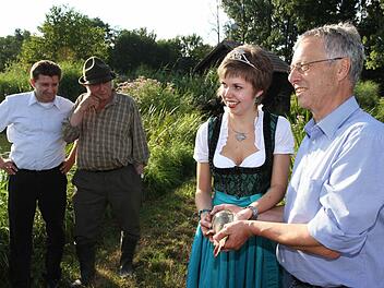 Thomas Speierl (l.) und Fritz Nagel schauen zu, wie Karpfenkönigin Katrin I. und Robert Klupp einen fangfrischen Karpfen in Händen halten.  Foto: Erlwein