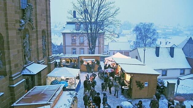Blick auf den stimmungsreichen Weihnachtsmarkt in Litzendorf im Schatten der Pfarrkirche Foto: Archiv/Gemeinde Litzendorf