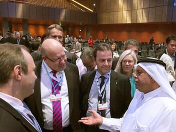 Bundesumweltminister Peter Altmaier (2.v.l, CDU) unterhält sich beim Klimagipfel in Doha mit dem katarischen Konferenzpräsidenten Abdullah bin Hamad Al-Attiyah quasi. Foto: Ingo Strube/BMU/dpa