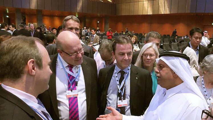Bundesumweltminister Peter Altmaier (2.v.l, CDU) unterhält sich beim Klimagipfel in Doha mit dem katarischen Konferenzpräsidenten Abdullah bin Hamad Al-Attiyah quasi. Foto: Ingo Strube/BMU/dpa