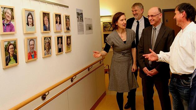 Tina Lenhart von der Gesundheitsregion plus, Klinik-Vorstand Stephan Kolck, Landrat Wilhelm Schneider und Herbert Ritter (von links) mit Teilnehmern vor Bildern .