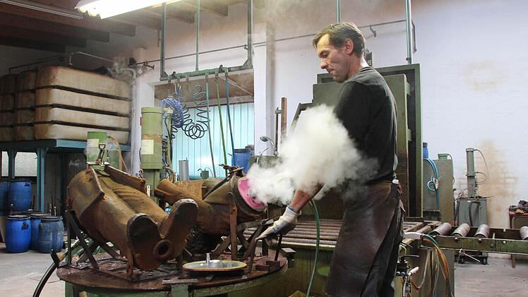 Ebenfalls mit Luft pustet er in die Metallform rein.