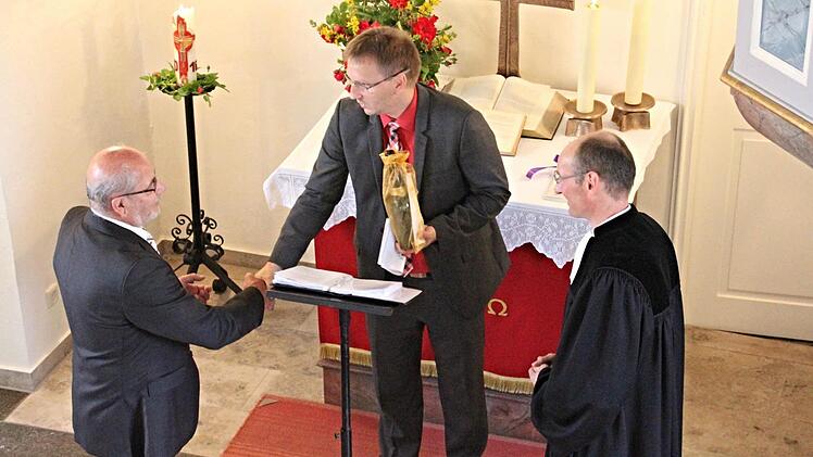 Gerne nimmt Kirchenvorstand Hans Merz (links) unter wohlwollendem Blick von Pfarrer Martin Popp-Posekardt (rechts) ein Präsent von Bürgermeister Wolfram Thein (Mitte) zum 250jährigen Bestehen der Kirche Eckartshausen entgegen. Foto: Helmut Will