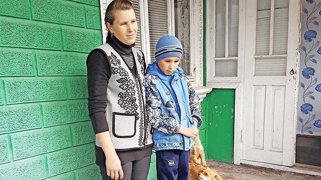 Die Mutter von vier Kindern mit ihrem kranken Sohn vor dem vom Missionsverein im letzten Jahr gekauften Haus Foto: Friedrich Dorsch