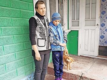 Die Mutter von vier Kindern mit ihrem kranken Sohn vor dem vom Missionsverein im letzten Jahr gekauften Haus Foto: Friedrich Dorsch