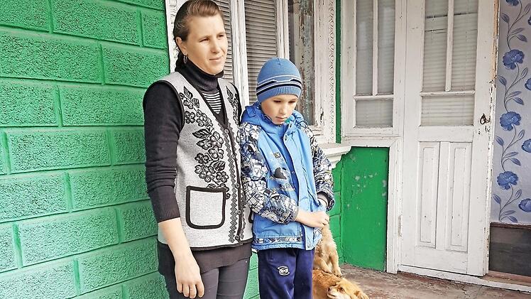 Die Mutter von vier Kindern mit ihrem kranken Sohn vor dem vom Missionsverein im letzten Jahr gekauften Haus Foto: Friedrich Dorsch