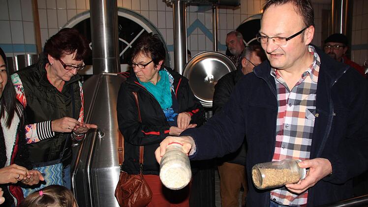 Im Sudhaus gab's etwas Leckeres. Reinhold Reblitz (rechts) ließ seine Gäste Malzkörner versuchen: "Des kann mer knabbern wie Erdnüss'", scherzte der Braumeister. Foto: Matthias Einwag