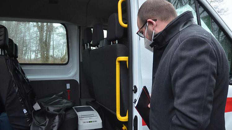 Landrat Sebastian Straubel betrachtet den Kühlbehälter, in dem die Impfdosen vom mobilen Impfteam mitgeführt werden. Fotos: Rainer Lutz