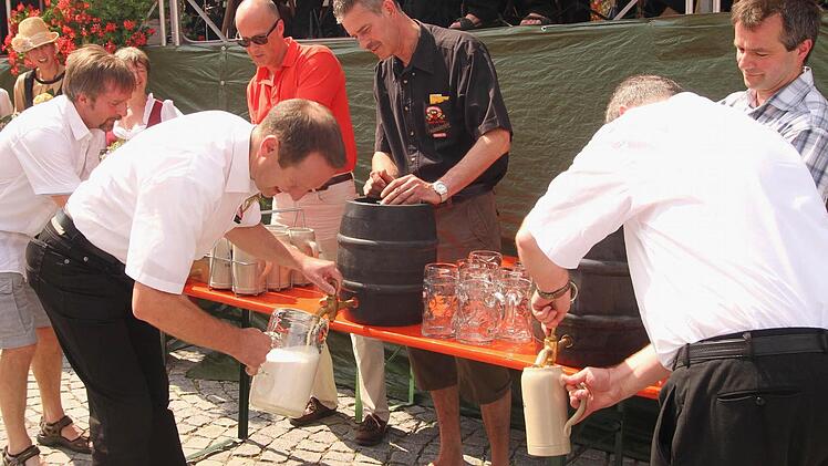 Festleiter Peter Klein, Bürgermeister Michael Ziegler und Pfarrer Thomas Klemm (vorne von links) steckten die Fässer der drei Brauereien an, und die Braumeister assistieren dabei.