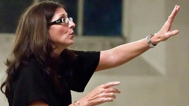 Mit klarer Gestik dirigiert Antoinetta Bafas den Chor "Unerhört" (großes Foto oben) beim Benefizkonzert in der Heilig-Kreuz-Kirche.